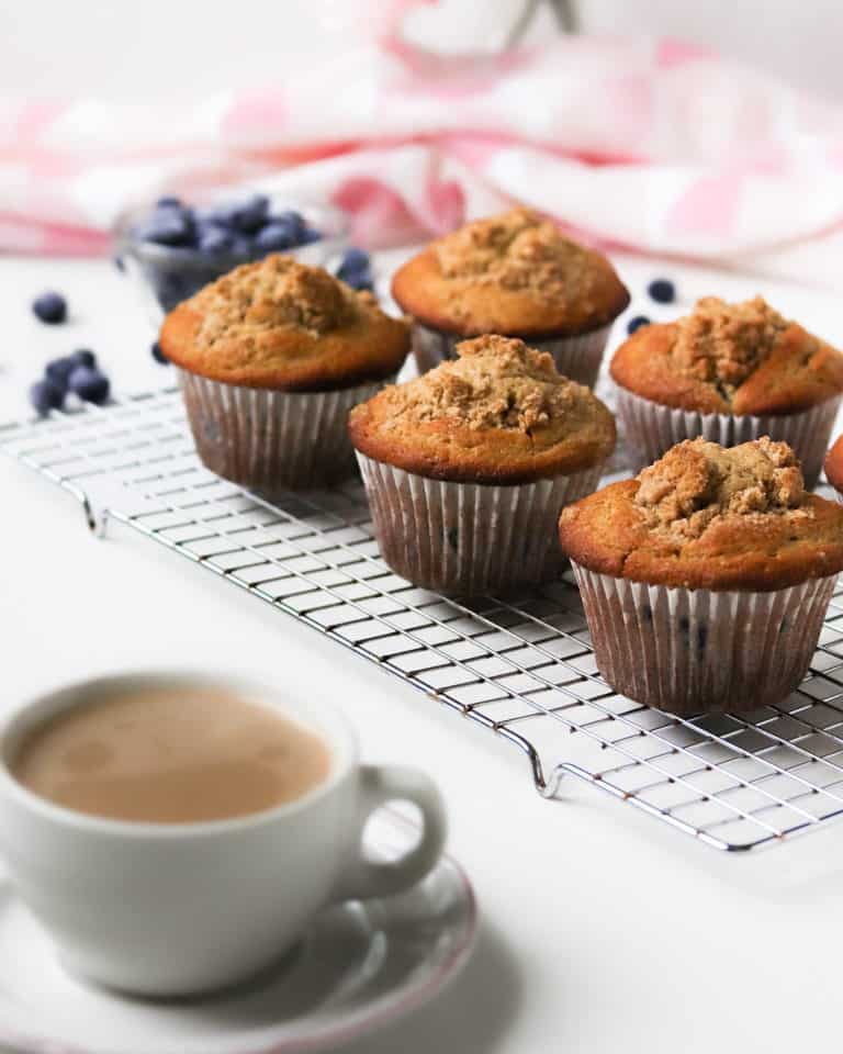 rack of jumbo whole wheat blueberry muffins with a cup of coffee