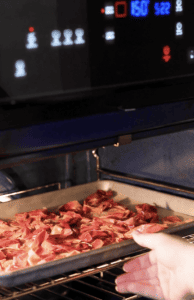 putting a sheet pan of peach skins into the oven