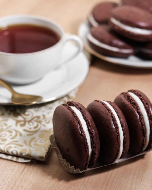three hot chocolate macarons with a cup of tea