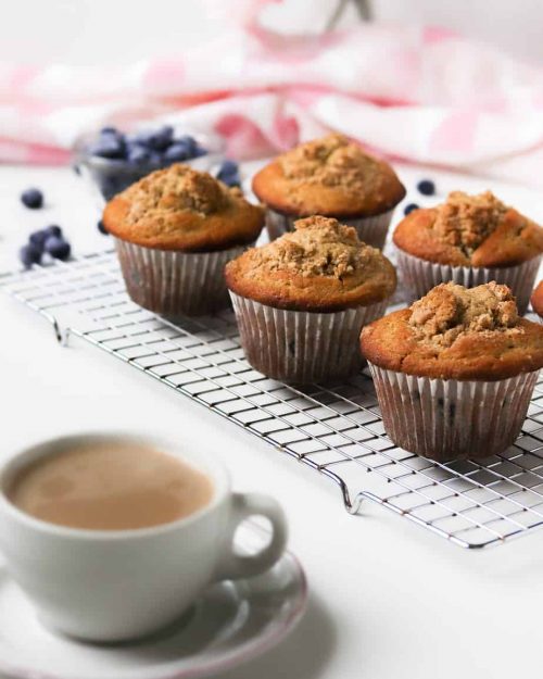 rack of jumbo whole wheat blueberry muffins with a cup of coffee